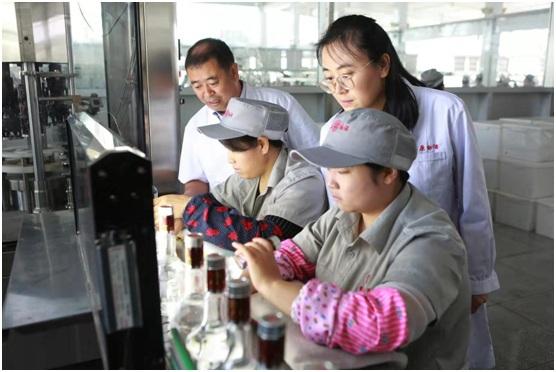 内蒙古自治区食品检验检测中心专家与草原酒业技术人员查看包装生产线上的“质量控制点”工作情况